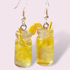 Capture the joy of summer with these miniature lemonade earrings! These adorable earrings are meticulously handcrafted to resemble mini jars filled with crystal-clear lemonade, adorned with tiny lemon slices for a burst of sunny color. Wear them to add a touch of whimsical charm to your summer outfits and infuse your days with the refreshing spirit of lemonade stands and carefree afternoons. Ideal for anyone seeking a playful accessory to brighten up their sunny adventures all season long! Fun Yellow Earrings For Summer, Lemon Accessories, Lemon Keychain, Lemon Slice Earrings, Lemon Miniatures, Miniature Food Earrings, Mini Jars, Quirky Earrings, Lemonade Stand