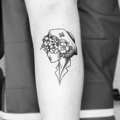 a black and white photo of a woman's head with flowers in her hair