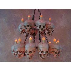 a chandelier with skulls hanging from it's sides and lit candles in the middle