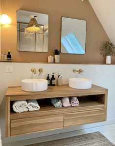 a bathroom with two sinks and mirrors on the wall