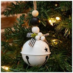 an ornament hanging from a christmas tree decorated with black, white and green ornaments