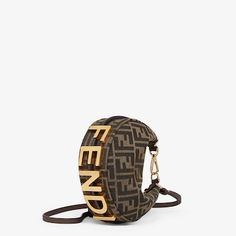 Mini hobo bag made of brown FF jacquard motif fabric, decorated with vintage gold metal FENDI lettering. Zip closure with fabric-lined internal compartment, gold-finish metalware. It can be carried by hand thanks to the hook and clip to use as a handle, or worn cross-body using the thin, adjustable, detachable shoulder strap. Holds a 6.2-inch smartphone, Mini Trifold card holder or wallet, keys and lipstick. Made in Italy. One Size Fendi Bag, Fendi Bag Outfit, I Do Shoes, Fendi Logo Design, Fendi Mini, Blue Leather Bag, Fendi Store, Small Leather Bag, Womens Designer Bags