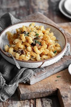 a bowl filled with macaroni and cheese on top of a wooden table