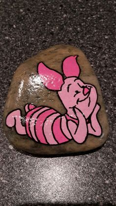 a rock with a pink winnie the pooh painted on it