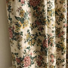 a curtain with flowers on it hanging in a room