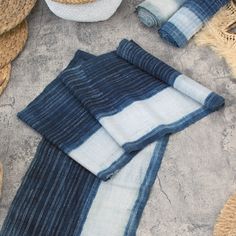 blue and white striped towels laid out on the ground next to some straw baskets,