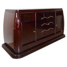 a large wooden cabinet with gold handles on it's doors and drawers, against a white background