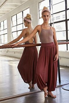 two young women are standing in front of a ballet pole and posing for the camera