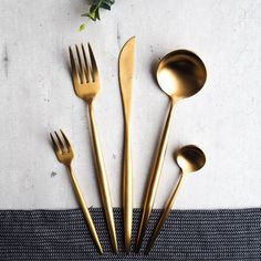 five golden forks and two spoons on a table