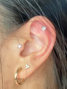 a close up of a person's ear with two piercings on top of it