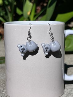 Embrace the charm of Australian wildlife with these adorable Handmade Hanging Koala Earrings! Each pair is meticulously crafted with love and attention to detail using polymer clay, making them lightweight and comfortable to wear all day long. These sweet koala earrings feature intricately sculpted koala figures hanging from earring hooks, capturing the playful essence of these beloved creatures.  Whether you're planning a trip to the zoo or adding a touch of nature to your everyday style, these koala earrings are sure to bring joy and whimsy to any outfit. They make a perfect gift for friends, family, or yourself! Each pair is handmade, so slight variations may occur, making each set truly one-of-a-kind Add a touch of Aussie charm to your jewelry collection with these delightful Hanging K