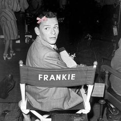 a black and white photo of a man sitting in a chair with the word frankie on it