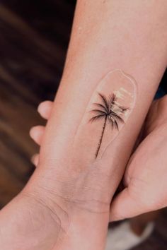 a small palm tree tattoo on the wrist