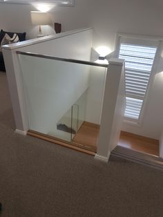 an empty room with a glass door on the bottom floor and stairs leading up to the second floor