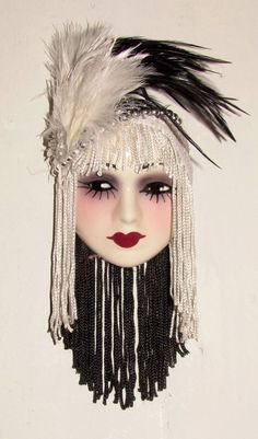 a doll with white and black feathers on it's head