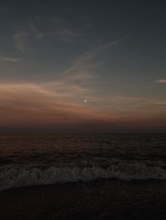 the sun is setting over the ocean with waves