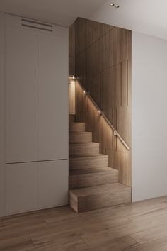 an empty room with wooden stairs and white walls