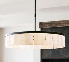 a chandelier hanging from the ceiling in a room with white walls and wood paneling