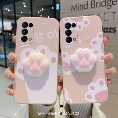 two cell phones with cat ears and bows on them, one is holding the other