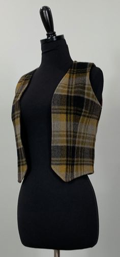 "B E S T  F I T S    Suggested Size: 00/0  Please check measurements below to ensure the best possible fit.      D  E  S  C  R I  P  T  I  O  N     *Black, gray, and golden-brown open vest  *Plaid pattern  *Open construction  *Pointed front hemline, square back  *Sleeveless   *Fully lined  *Cropped  *There is no stretch to the item  *1960s - 1970s era    D  E  T  A  I  L  S     * Fabric: No label - plaid fabric: possibly wool or wool blend - Lining: possibly acetate  * Care: No label  * Marked S Preppy Plaid, Gray And Brown, Plaid Vest, 60s Mod, Cropped Vest, Plaid Fabric, Brown Plaid, Vest Outfits, Gray Plaid