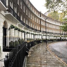 a row of buildings on the side of a street with trees in front of them