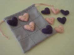 small felt hearts are placed on a gray bag