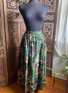 "90s green floral midi skirt by Charter Club. Buttons closed, pleated in the waist and has pockets. 100% rayon Excellent vintage condition! No stains or holes. Always use measurements for more accurate sizing. Tag labels are meaningless. This is slightly pinned on my modern 6/S mannequin. Go by measurements. Measurements taken laying flat/Double number where applicable: WAIST: 15\" across LENGTH: 35.5\" ALL SALES ARE FINAL SO PLEASE DOUBLE CHECK THE MEASUREMENTS PRIOR TO BUYING AND DON'T HESITATE TO REACH OUT IF YOU HAVE ANY QUESTIONS!  All items are vintage/preloved and may have small imperfections. This should be expected for secondhand clothing. ALL MAJOR FLAWS WILL BE NOTED IN THE DESCRIPTION AND PHOTOGRAPHED." Green Floral Print Long Skirt, Green Floral Print Relaxed Skirt, Retro Green Long Skirt Bottoms, Green Floral Print Midi Skirt, Retro Green Long Skirt, Green Bohemian Maxi Skirt With Floral Print, Green Floral Print Flowy Skirt, Vintage Green Long Skirt, Vintage Long Green Skirt