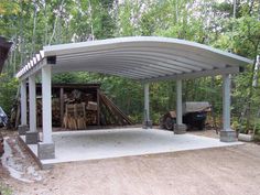 a covered parking lot in the middle of a wooded area