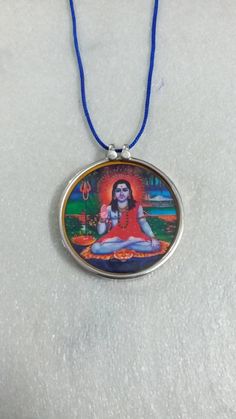 Handmade 92.5 Sterling Silver The Great Sant of Gorakh sampradaya India Yogi Guru Gorakhnath Hindu Religious Photo Print Glass Framed Pendant With Colour String. Made by My Shop Members. Primary Colour of pendant is Silver. Pendant Length With Loop 4.3 cm Pendant Width 4.1 cm. Pendant Weight 7 gms. Few Golden Colour Hand Work On Photo Print ,Not Total Hand Painted. Handmade Pendant covered by 92 5 silver and glass. Temple Necklace With Round Pendant For Festivals, Handmade Necklace For Puja And Navratri, Handmade Necklace For Puja During Navratri, Round Amulet Necklaces For Puja, Multicolor Spiritual Necklace For Puja, Round Spiritual Temple Necklace As Gift, Spiritual Round Temple Necklace As Gift, Navratri Gift Temple Necklace, Round Necklace For Navratri Puja