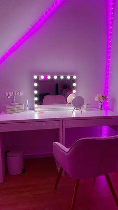 a desk with a chair, mirror and lights on it in front of a purple wall