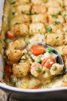 a casserole dish with chicken and vegetables in it is being spooned into the casserole