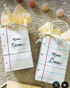 two paper bags with writing on them sitting on the floor