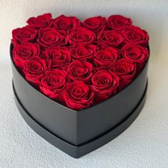 a heart shaped box filled with red roses