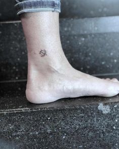 a person's foot with a small tattoo on the side of their left leg