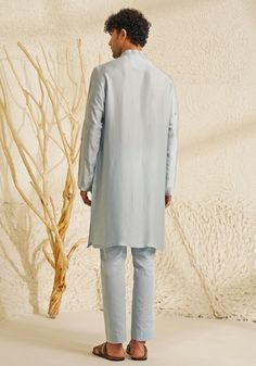 Featuring a stylish Powder Blue Chanderi Silk Kurta Set, complemented by metallic silver buttons that add a touch of grace. Teamed with matching pants for an elegant look, this ensemble is perfect for an engagement, Roka or Sangeet, blending sophistication with contemporary charm. Composition : Chanderi Silk Care: Dry Clean Only and Vacuum Storage This product can be customized for sleeves, length and colour Delivery : 4-6 weeks as the product is hand crafted. Check Size Guide or choose MySize for free customisation (All Sizes above XL can be made at 15% additional cost) For more information and sizes please contact fabiliciousfashion@gmail.com or visit our Copenhagen studio. About the Designer : Shreyansh, a distinguished designer label specializing in luxurious ethnic menswear for weddin Designer Blue Sets With Dabka Detailing, Designer Blue Sets For Eid, Elegant Blue Designer Wear Pant Set, Elegant Blue Designer Pant Set, Elegant Blue Pant Set For Designer Wear, Elegant Semi-formal Sets For Diwali, Elegant Kurta With Traditional Drape For Semi-formal Occasions, Elegant Festive Semi-formal Kurta, Elegant Semi-formal Blue Traditional Wear