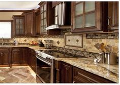 a kitchen with brown cabinets and marble counter tops