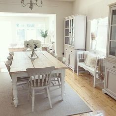 a dining room table and chairs with white furniture