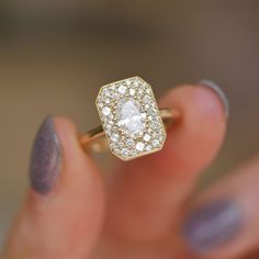 a close up of a person holding a ring with a diamond in it's center