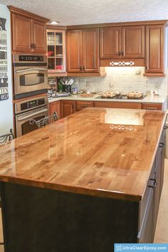 a kitchen with wooden cabinets and an island counter top in the middle of the room