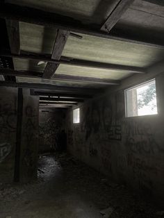 an empty room with graffiti all over the walls and ceiling, along with two windows