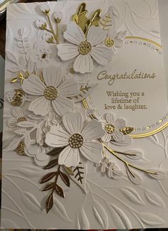 a white card with gold foiling and flowers on the front, says congratulations wishing you a lifetime of love & laughter