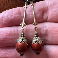 Simple vintage inspired earrings with 10mm Swarovski Bordeaux/Wine colored Crystal Pearls. The earrings are accented with antiqued brass bead caps. They are approximately 2.5 inches long and come in a gift box. Red Brass Earrings With Ear Wire, Vintage Red Drop Clip-on Earrings, Red Vintage Style Drop Clip-on Earrings, Vintage Red Brass Earrings, Red Brass Drop Earrings, Vintage Red Clip-on Earrings As Gift, Unique Red Brass Earrings, Unique Red Earrings For Formal Events, Unique Red Earrings For Formal Occasions