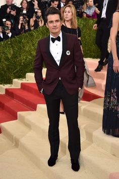 a man in a tuxedo and bow tie standing on stairs at an event