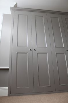 an empty room with some gray cupboards and carpeted flooring in front of it