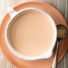 there is a bowl of soup with spoons on the plate