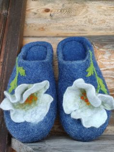 a pair of blue slippers with white flowers on them