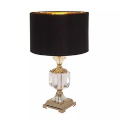 a table lamp with a black shade on the top and gold trimming around it