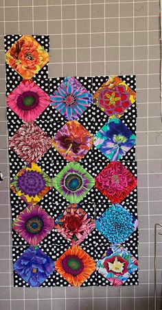 a black and white tiled wall with colorful flowers on it