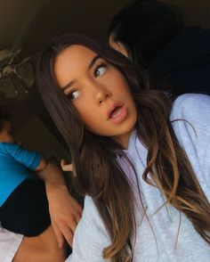 a woman with long brown hair and blue shirt