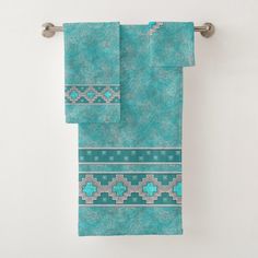 two towels hanging on a towel rack in front of a white wall with the words southwest turquoise by artillos